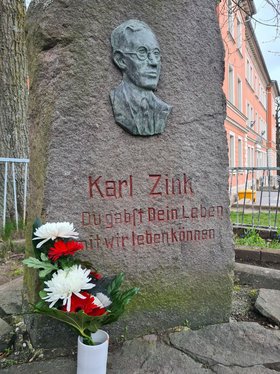Das Karl-Zink-Denkmal in Ilmenau. Im Vordergrund eine Vase mit einem Blumenstrauß.
